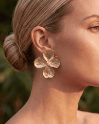A pair of DIDI Gold Earrings from AUKA STUDIO, featuring sleek gold jewelry design on a plain background.