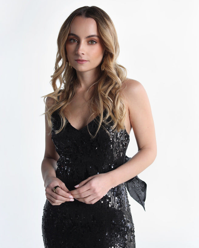 Auka Studio Triana black dress, stylish sleeveless vestido with a fitted silhouette, displayed on a hanger.