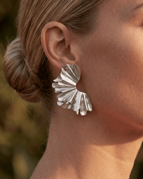 Silver earrings from AUKA STUDIO featuring sleek, minimalist design with a polished finish, displayed on a white background.